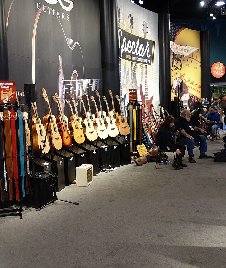 A row of acoustic guitars displayed at the 2016 NAMM Show.