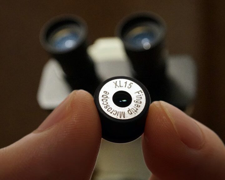 iMicro XL15 fingertip microscope lens held between two fingers